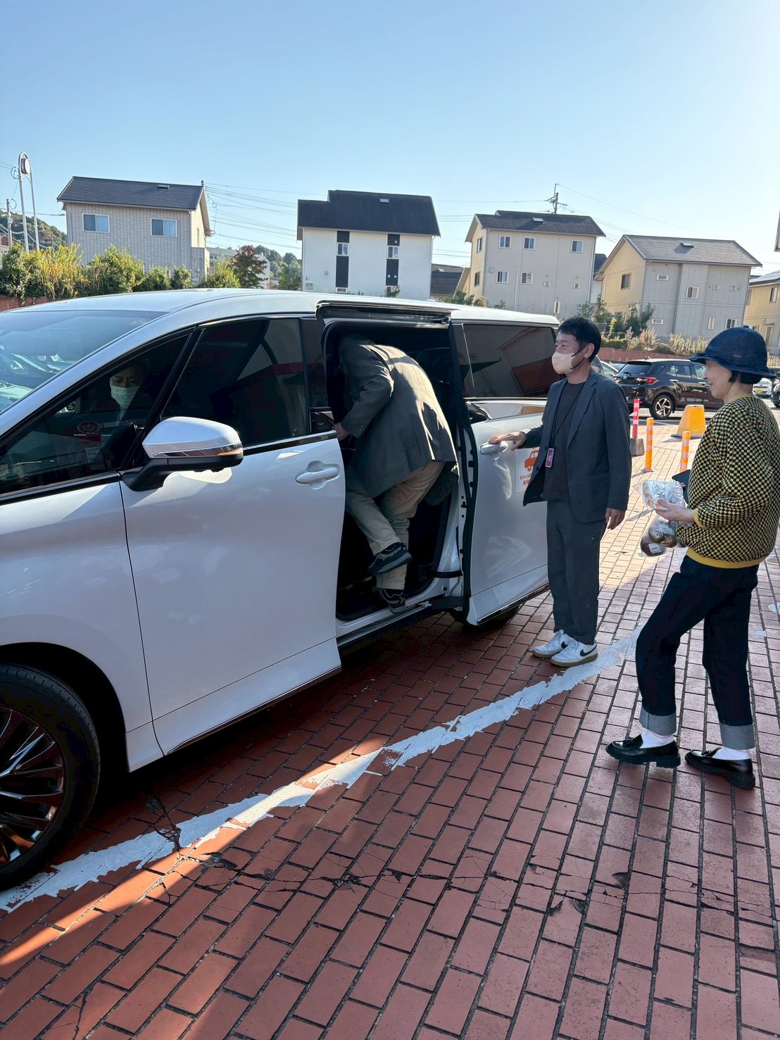 富士見が丘の実証車両に住民が乗り込むそばで、スタッフが見守っている