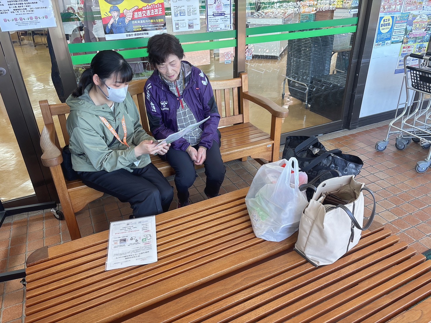 富士見が丘の店舗前で、スタッフと住民が資料を見ながら話している