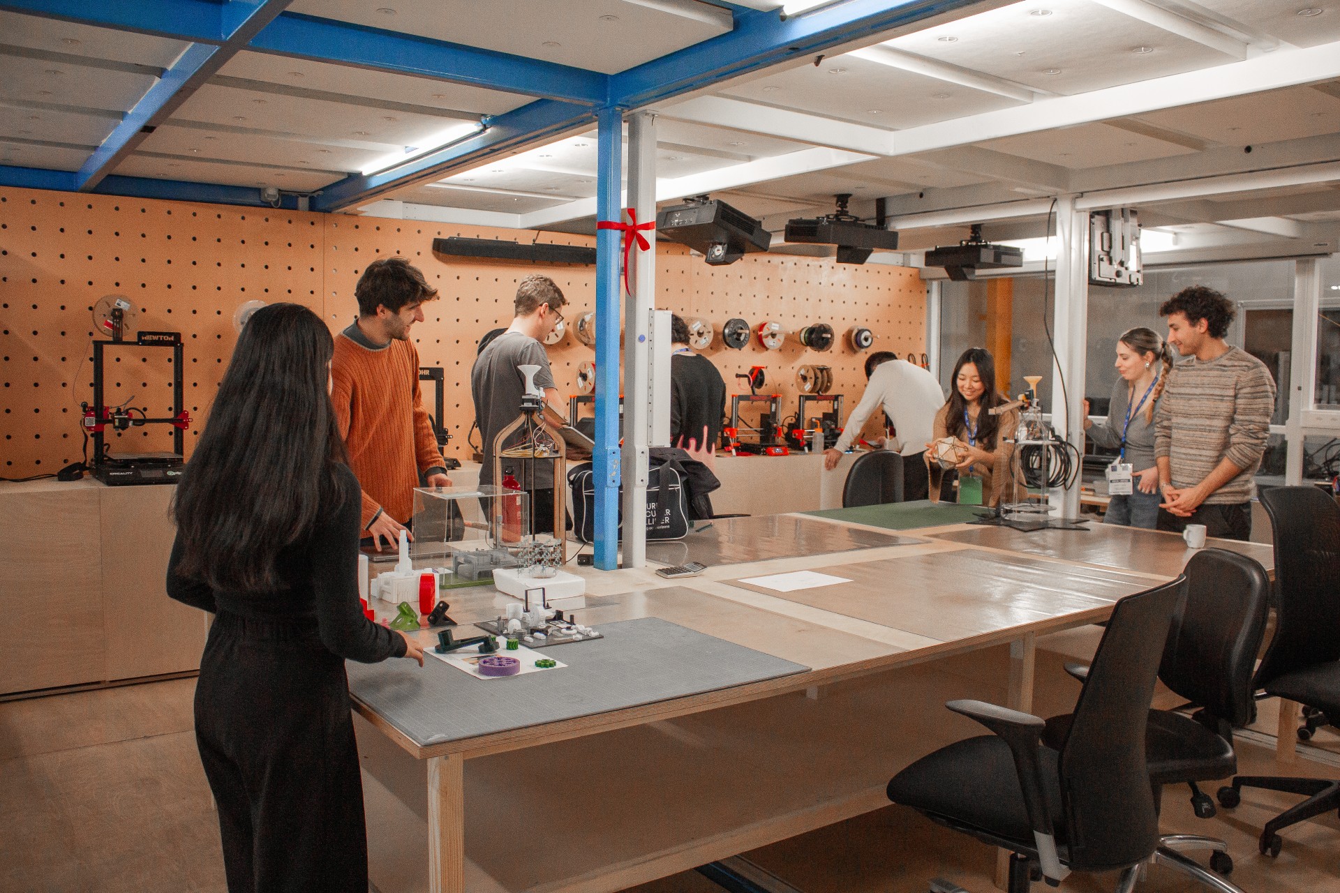 2026年に公開されたCERN IdeaSquareの新しい試作工房The Forge。作業台を囲む利用者と工具壁を写した実写。